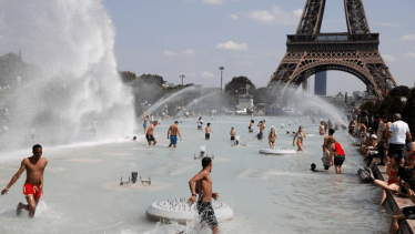 En las piletas y fuentes de la Torre Eiffel, las personas buscan refrescarse (Reuters)
