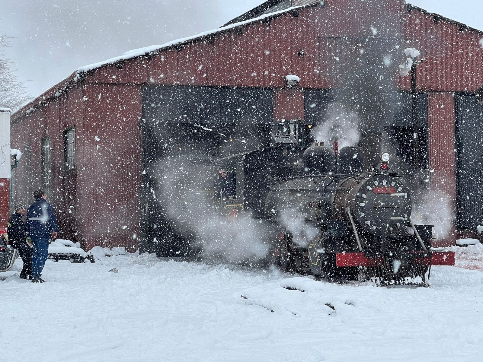 Los mecánicos de La Trochita, bajo la nevada, trabajaron en el legendario tren a vapor para la excursión de Jacobacci a la estación Empalme. Fotos: Gabriel Asenjo 