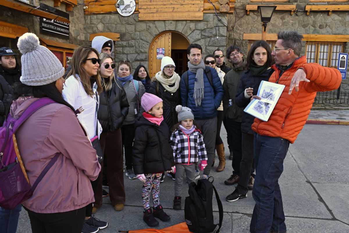 Con paraguas naranja abierto para ser reconocido por el grupo, Máximo Daulte, sale cada día a las 9:45 a guiar el tour “Descubre la historia de Bariloche”. Fpto: Alfredo Leiva.