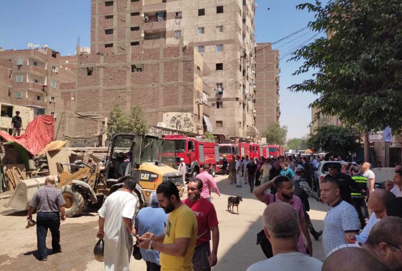 Bomberos y caminantes, junto a la iglesia copta que se ha incendiado este domingo en Giza. Foto gentileza El País. 