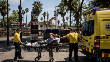 Durante la ola de calor, en Barcelona, una persona era asistida por personal de salud, en plena calle. Fuente: El País. 