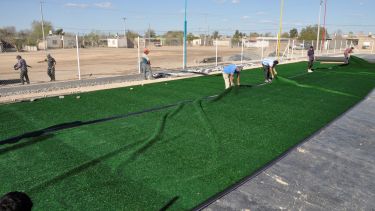 Ayer comenzaron a colocar el césped sintético en la cancha de jockey seven de Valcheta. Foto: José Mellado. 
