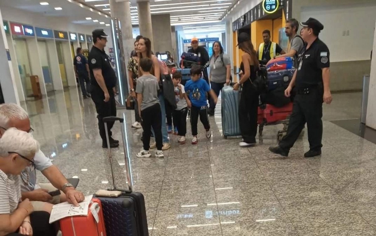 Antonella Roccuzzo y sus tres hijos al llegar ayer al aeropuerto de Puerto Iguazú con otros familiares. Mientras tanto,, Lionel Messi juega hoy por la Champions League en París.