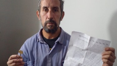 Cristian Barrera mostrando la denuncia que realizó contra el propietario y la llave del de la vivienda. Foto: Gentileza