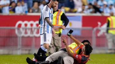 un hincha fue interceptado mientras se metió durante el partido para saludar a Messi. Foto: AP