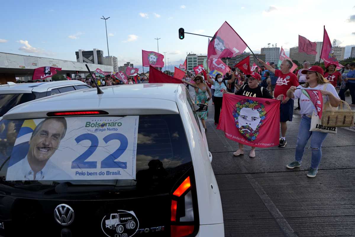 Seguidores del candidato a presidente Luiz Inacio Lula da Silva  rodean el auto de un seguidor del candidato a la reelección Jair Bolsonaro. (AP Photo/Eraldo Peres)