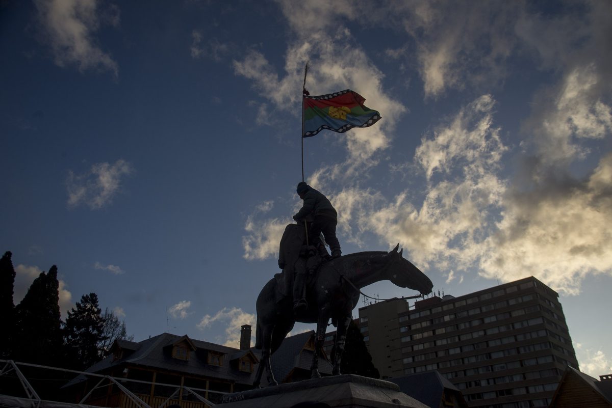 Cuando la marcha llegó al Centro Cívico, un militante subió al monumento del general Roca, le cubrió el rostro y colocó una bandera mapuche. (Foto Marcelo Martínez)
