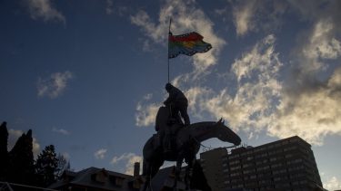 Cuando la marcha llegó al Centro Cívico, un militante subió al monumento del general Roca, le cubrió el rostro y colocó una bandera mapuche. (Foto Marcelo Martínez)