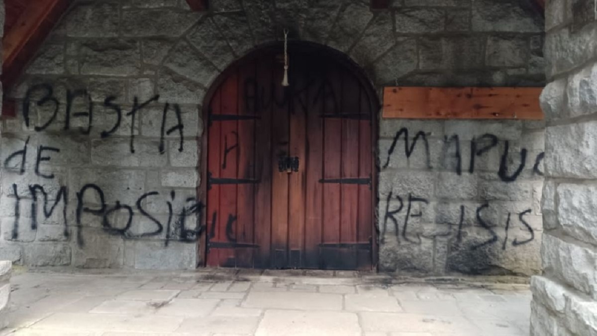 Las pintadas con aerosol negro fueron plasmadas en el exterior del edificio de la capilla Nuestra Señora de la Asunción, en Villa La Angostura. Foto: Gentileza Diario Andino