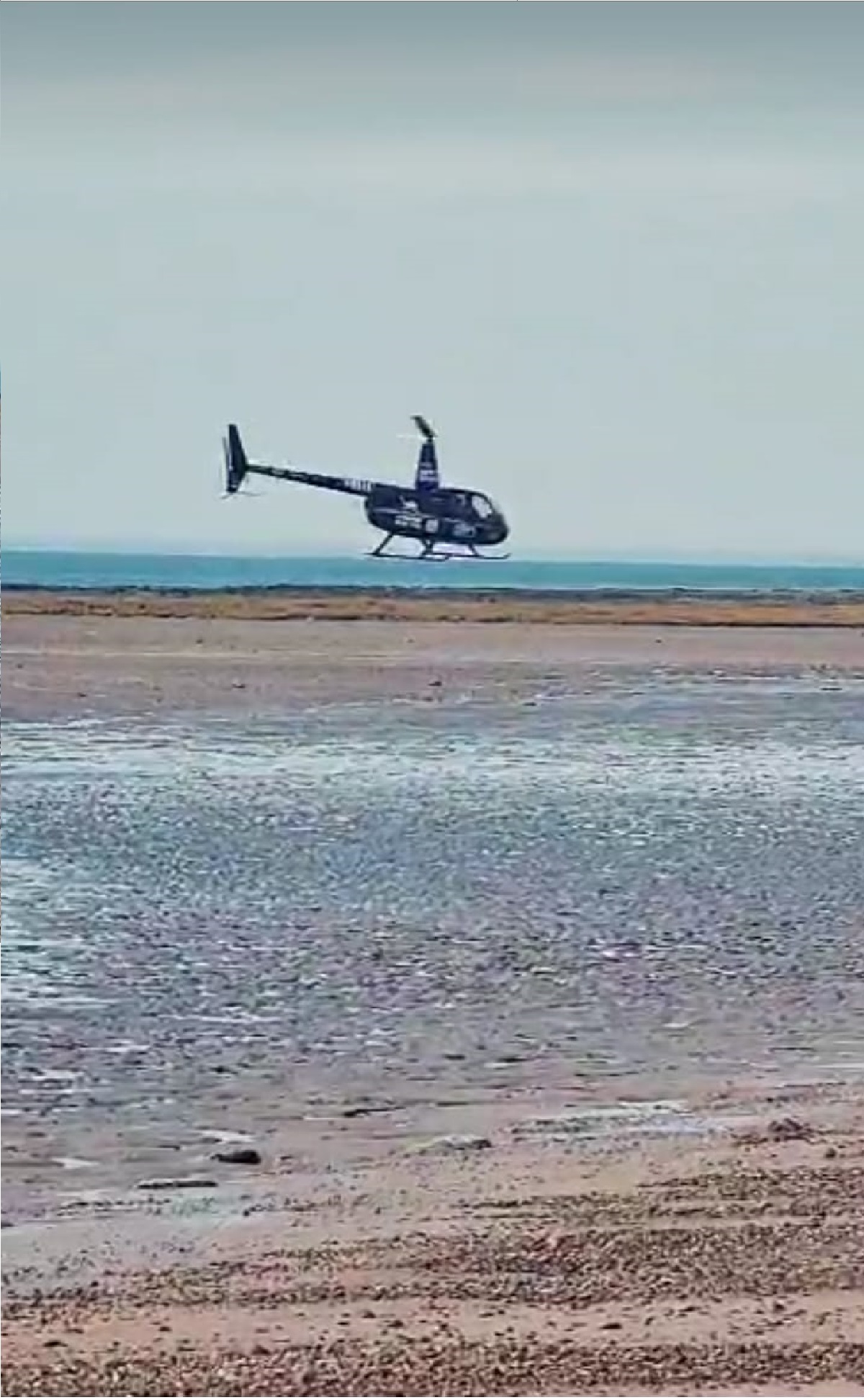 El helicóptero de la firma de turismo aventura, realizando vuelos rasantes en las playas de Él Sótano, al sur de Las Grutas.  Desde allí se trasladó a Sierra Grande   Foto: Gentileza