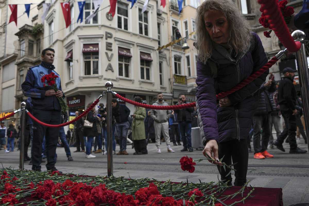La gente pone flores sobre un monumento colocado en el lugar de la explosión del domingo en la popular avenida peatonal Istiklal de Estambul. Foto AP. 