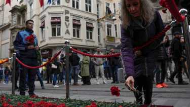 La gente pone flores sobre un monumento colocado en el lugar de la explosión del domingo en la popular avenida peatonal Istiklal de Estambul. Foto AP. 