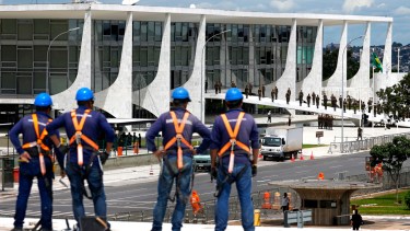 Trabajadores observan los preparativos de seguridad para la ceremonia de investidura del presidente electo de Brasil, Luiz Inácio Lula da Silva, en el Palacio Presidencial de Planalto, en Brasilia, Brasil, el martes 27 de diciembre de 2022. (Foto AP/Eraldo Peres)