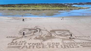 Dos ídolos: Lionel Messi y el Dibu Martínez, cerca de la tercera bajada de Las Grutas. Este sábado se repite la cábala, porque el domingo el mar estará pleno a la hora del partido, y no se podrá dibujar