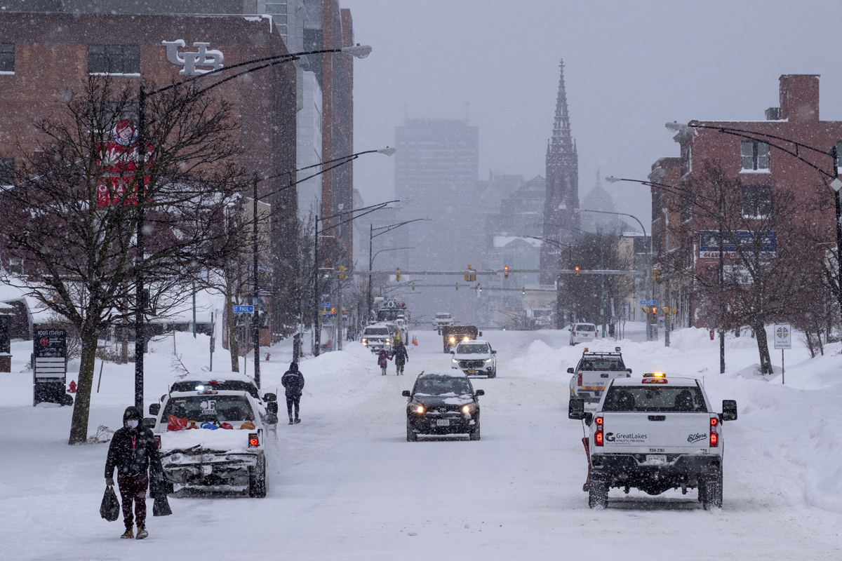 Personas y vehículos se mueven por Main St. en Buffalo, Nueva York, después de que una gran tormenta de nieve cubriera la ciudad. Junto con las derivas y las prohibiciones de circulación, muchas calles quedaron intransitables debido a los vehículos abandonados. AP Photo - Craig Ruttle