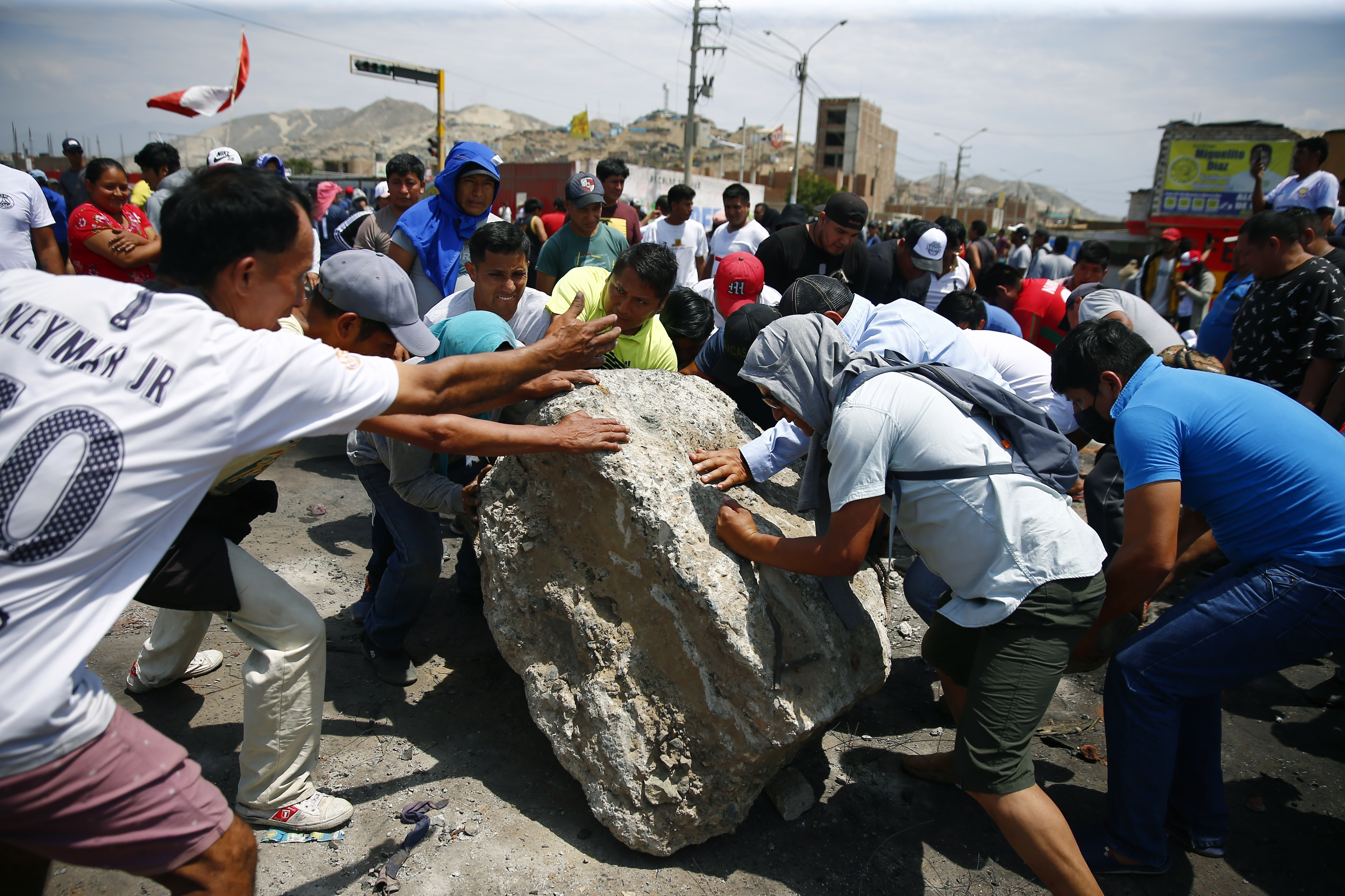 Supporters of ousted Peruvian President Pedro Castillo work together to roll a boulder onto the Pan-American North Highway during a protest against his detention, in Chao, Peru, Thursday, Dec. 15, 2022. Peru's new government declared a 30-day national emergency on Wednesday amid violent protests following Castillo's ouster, suspending the rights of "personal security and freedom" across the Andean nation. (AP Photo/Hugo Curotto)