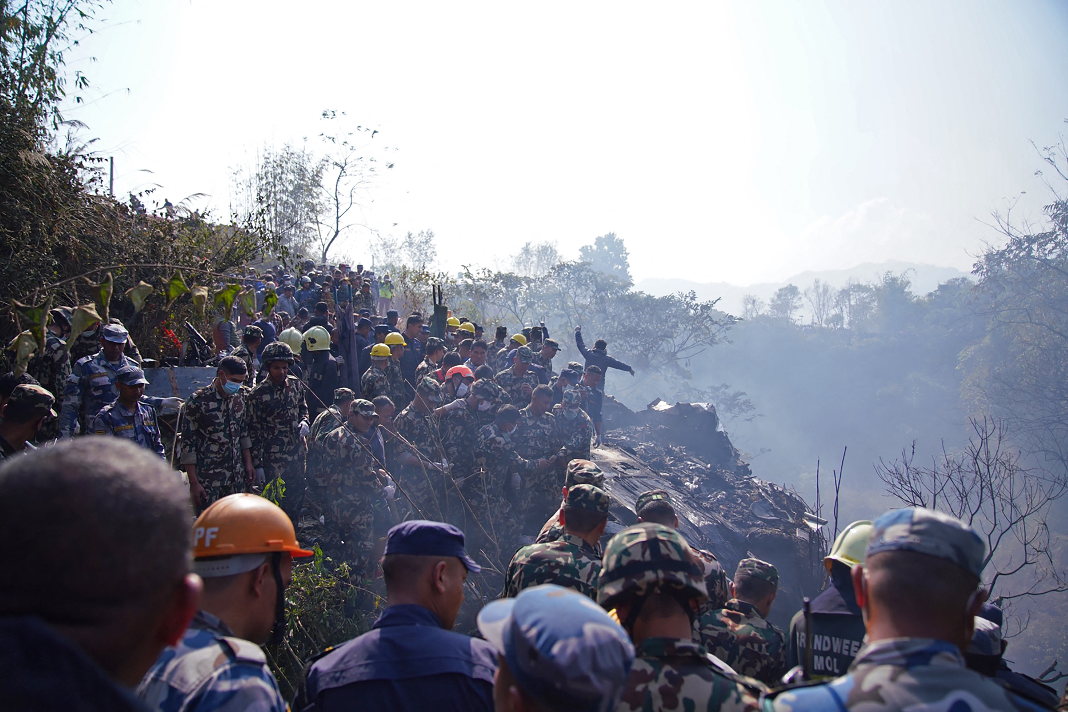 Los rescatistas continúan con las tareas en el lugar del accidente aéreo, sobre la ciudad de Pokhara en Nepal. Foto AFP/Yunish Gurung.
