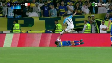 Gómez remata, la pelota pega en Sández, vuelve a impactar en el jugador de Racing y después en la mano del defensor del Xeneize. 