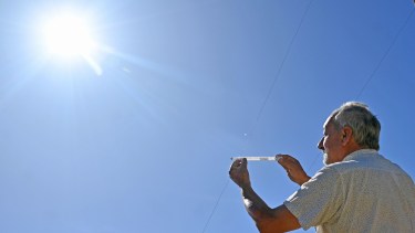 Merlino termómetro en mano, actividad que realiza todos los días para obtener la temperatura máxima. (Foto Florencia Salto)