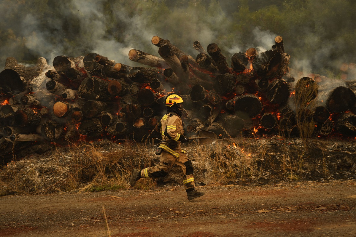 Un bombero corre a combatir las llamas en una de las decenas de localidades afectadas por los incendios. 