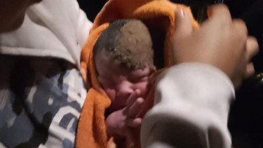 La foto del bebé, aún con tierra en la cabeza, con la que se difundió la impresionante historia de este sábado (Facebook radio comunitaria Quimunche)