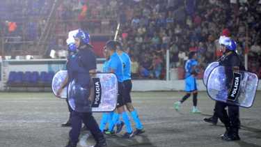 Román Domínguez y la terna arbitral escoltados por la policía. Fotos: Andrés Maripe 