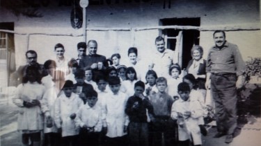 De pie y sin guardalpolvo, Enrique aparece en el extremo derecho. María Emilia, se encuentra entre los demás, luciendo el cabello recogido en un peinado de la época. De Nevares, inconfundible, es el de la sotana oscura, debajo del escudo de la Escuela 44 - Foto: Álbum Familia Gilardi, cedido a a la Base de Historia de las Escuelas Primarias de Neuquén.