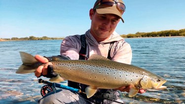 Una de las famosas truchas del Limay Medio en las manos de Matías Fernández Carro antes de la devolución,