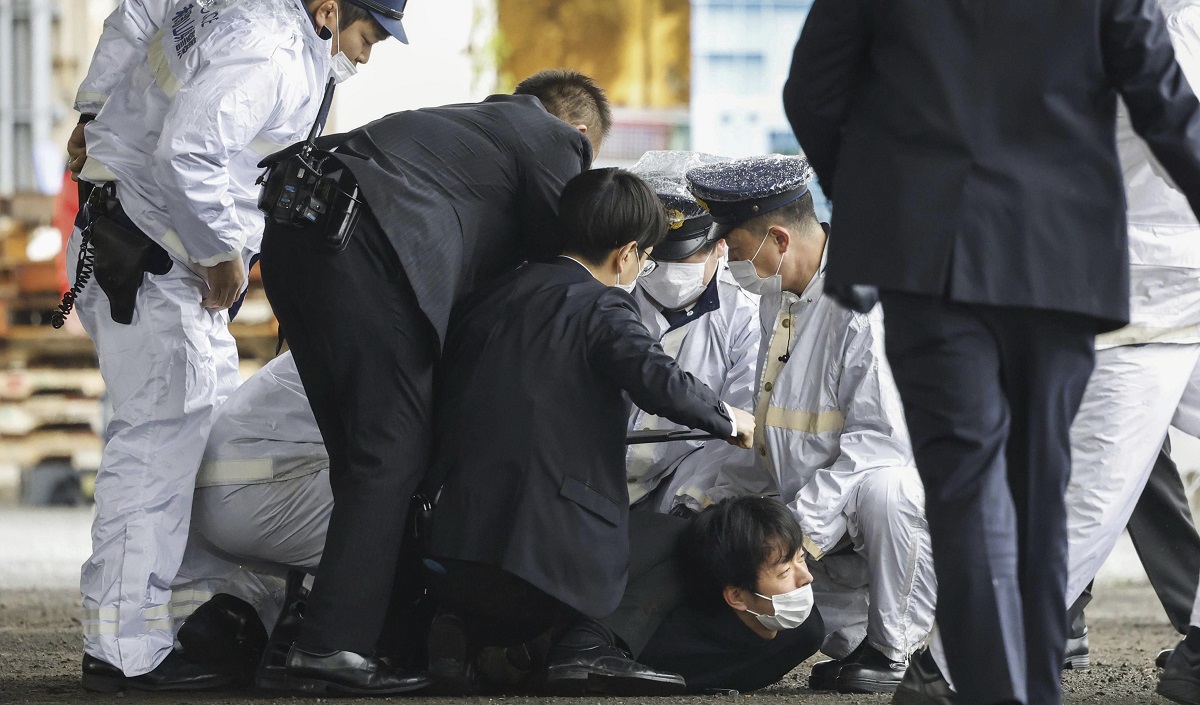 Los policías japoneses se arrojan contra el supuesto autor del atentado.