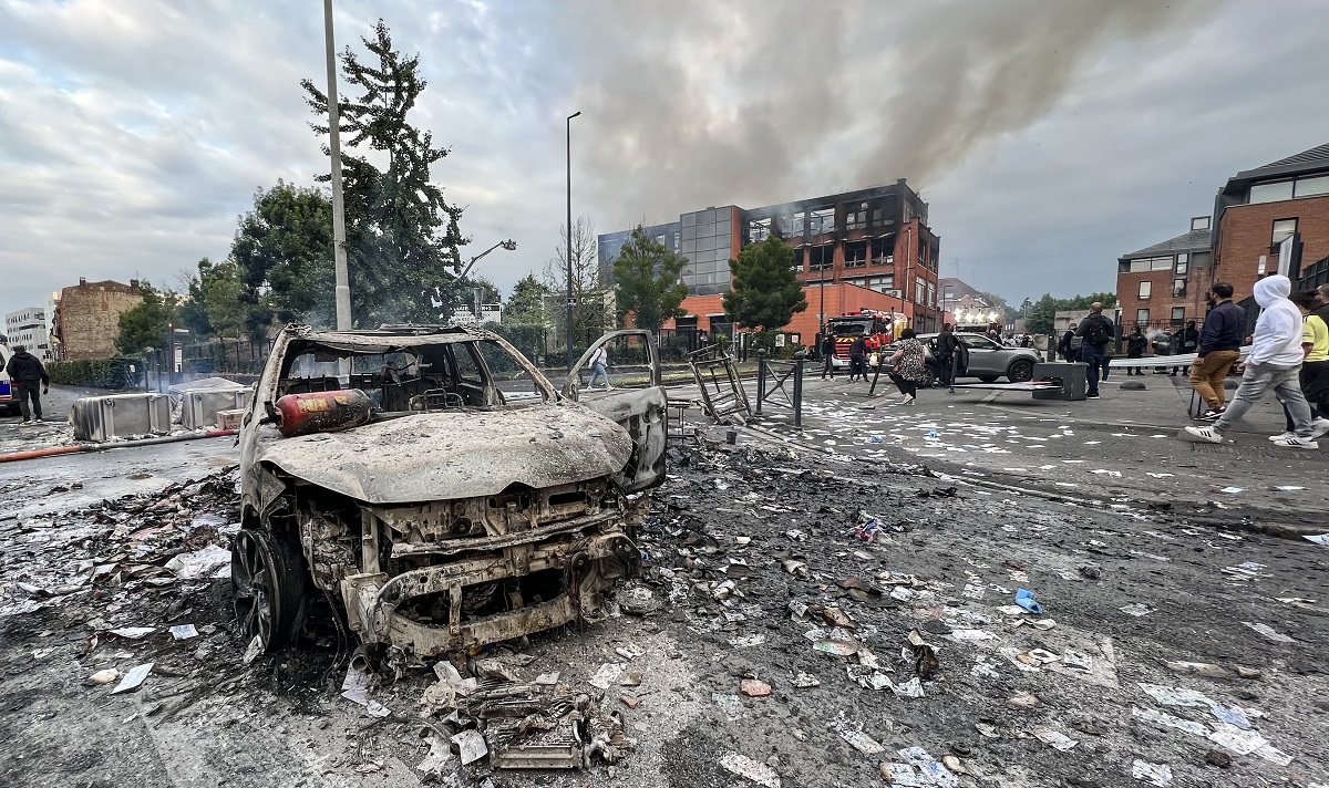 Un vehículo incendiado en una calle frente al edificio del grupo Tessi. Foto AFP. 