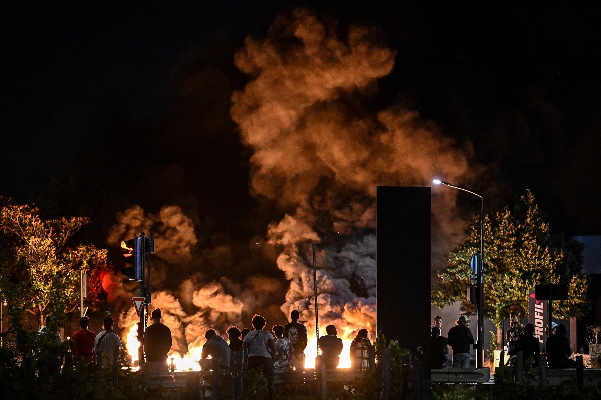 La gente mira los neumáticos en llamas que bloquean una calle en Burdeos, suroeste de Francia. Foto AFP. 