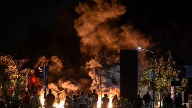 La gente mira los neumáticos en llamas que bloquean una calle en Burdeos, suroeste de Francia. Foto AFP. 