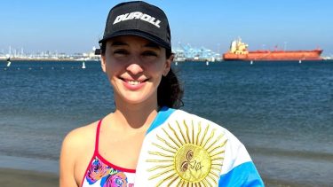 Ailén Lascano Micaz y la bandera argentina que la acompañó durante el viaje.