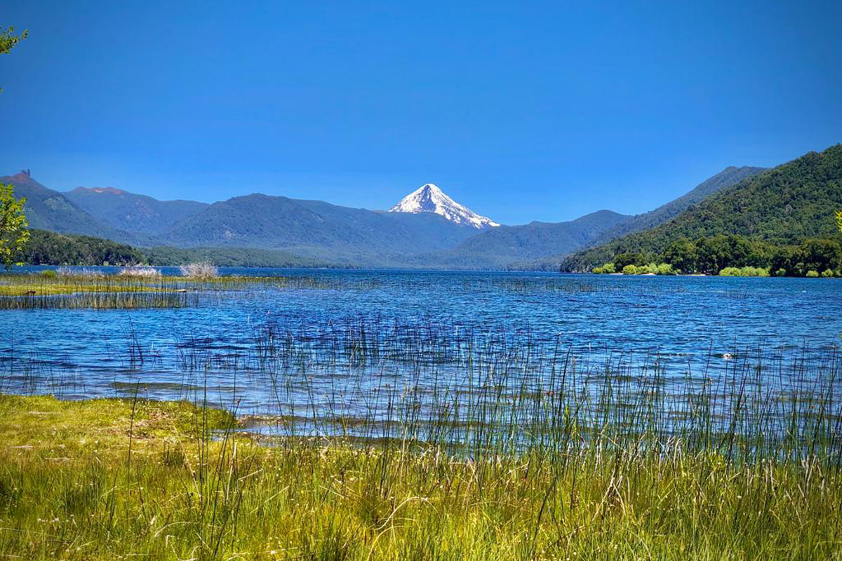 Postal del lago Quillén, belleza pura en la cordillera neuquina. De fondo, un ícono de la Patagonia: el volcán Lanín. 