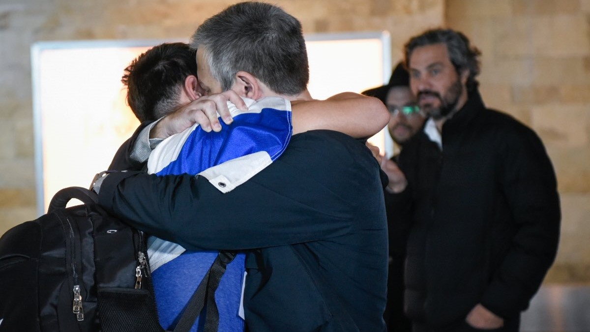 Familiares se abrazan emocionados en el Aeropuerto de Ezeiza mientras los argentinos regresan a casa desde Israel como parte del operativo "Retorno Seguro" después del ataque de Hamás. Foto X @SantiagoCafiero.