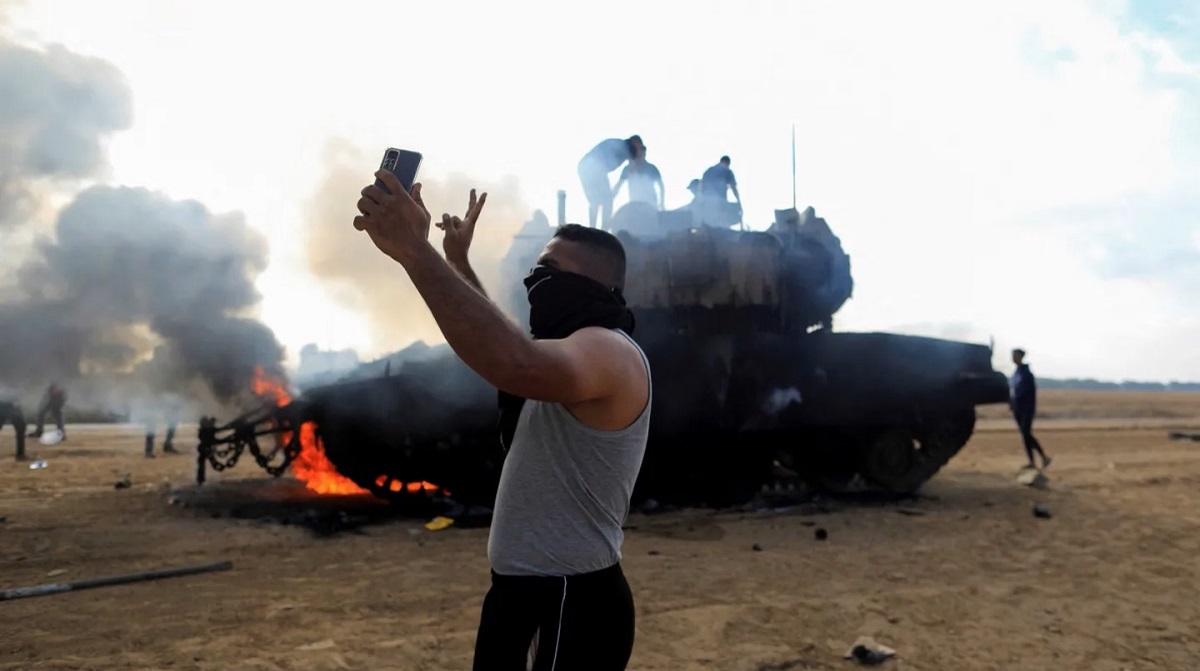 Un palestino se saca una selfie frente a un tanque israelí en llamas cerca de la frontera con la Franja de Gaza Foto: Yasser Qudih