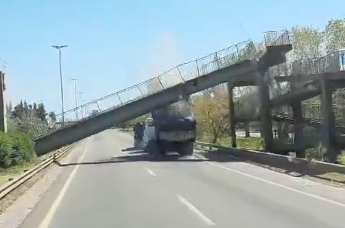 El conductor de un camión chocó contra un puente peatonal y lo derribó. Foto: Captura video