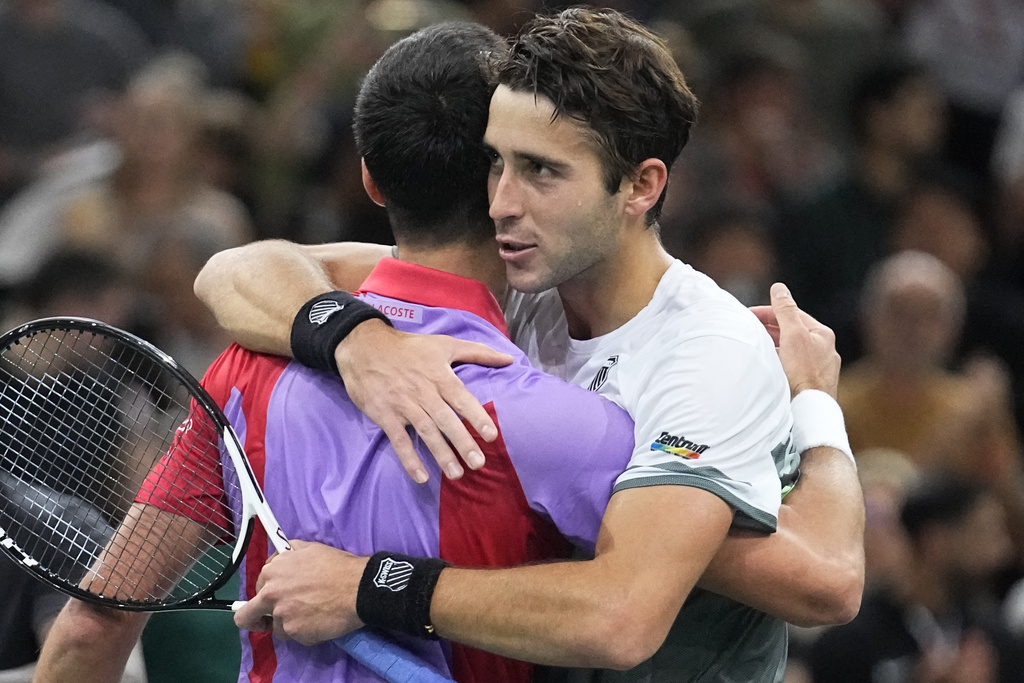 Novak Djokovic abraza a Tomas Etcheverry luego del partido por la segunda ronda del Masters 1000 de París. (AP Photo/Michel Euler)