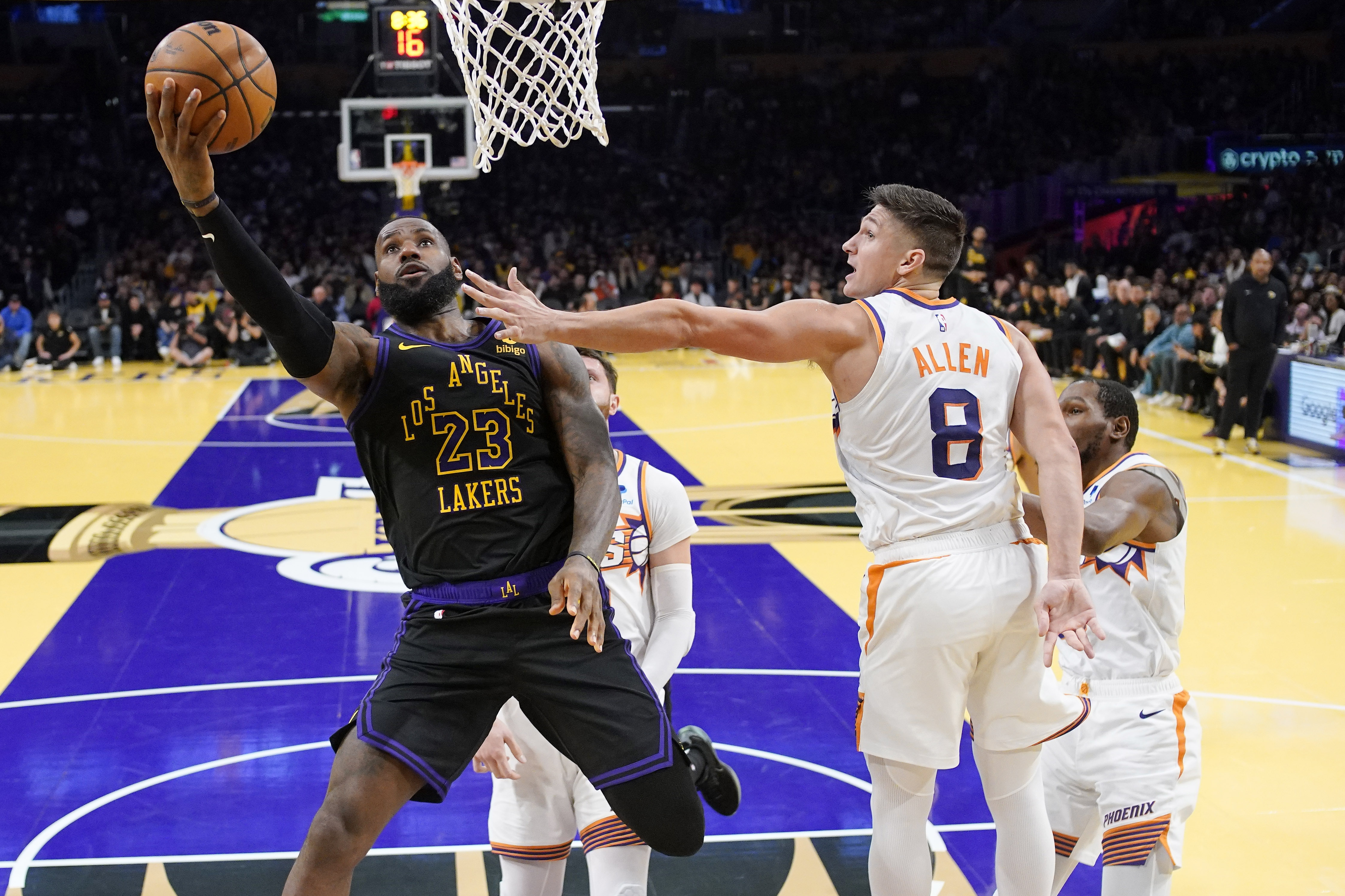 Los Angeles Lakers forward LeBron James, left, shoots as Phoenix Suns guard Grayson Allen defends during the second half of an NBA basketball In-Season Tournament quarterfinal game Tuesday, Dec. 5, 2023, in Los Angeles. (AP Photo/Mark J. Terrill)