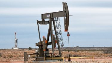 FILE PHOTO: A pump jack operates in front of a drilling rig owned by Exxon near Carlsbad, New Mexico, U.S. February 11, 2019. Picture taken February 11, 2019. To match Insight USA-SHALE/MAJORS . REUTERS/Nick Oxford/File Photo
