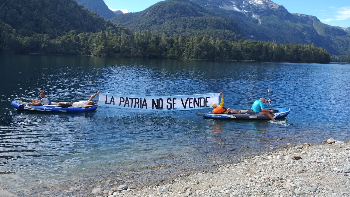 En el lago Sobería, un espejo de agua antes del Escondido, la columna Juana Azurduy desplegó la bandera "la patria no se vende". Foto: Gentileza
