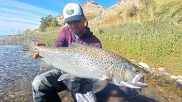 El guía Pablo Oscar Blasco y la gran trucha que pescó días atrás en la desembocadura del Limay Medio