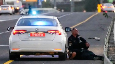 Policías se protegen de los misiles lanzados desde Irán que impactaron en Israel. (Foto AP/Ohad Zwigenberg)
