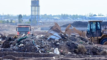 La montaña de residuos peligrosos en el Distrito 6 está en medio del loteo: al fondo de la apertura de calles, el tanque de agua para el sector (foto Cecilia Maletti)