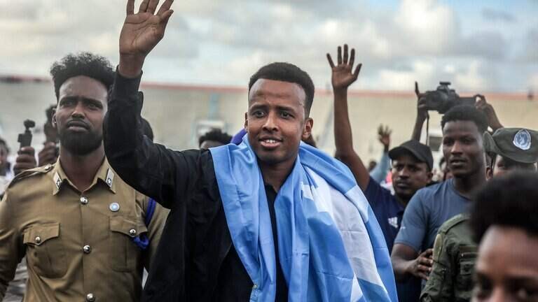 El árbitro somalí Omar Abdulkdir Artan saludando a las miles de personas que lo recibieron en el aeropuerto. (Foto: AFP)