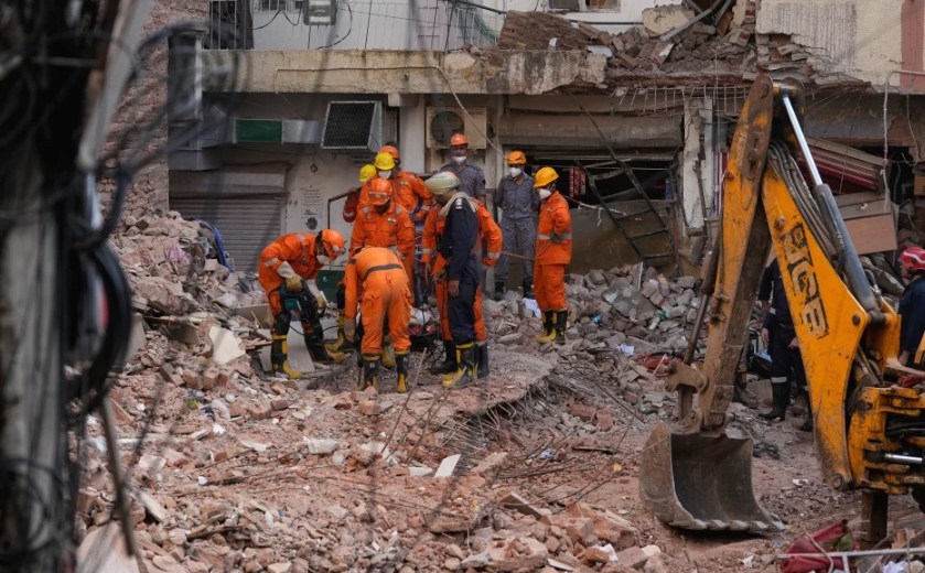 Rescatistas siguen buscando a personas atrapadas bajo los escombros de un edificio derruido en Nueva Delhi. Foto: AP.